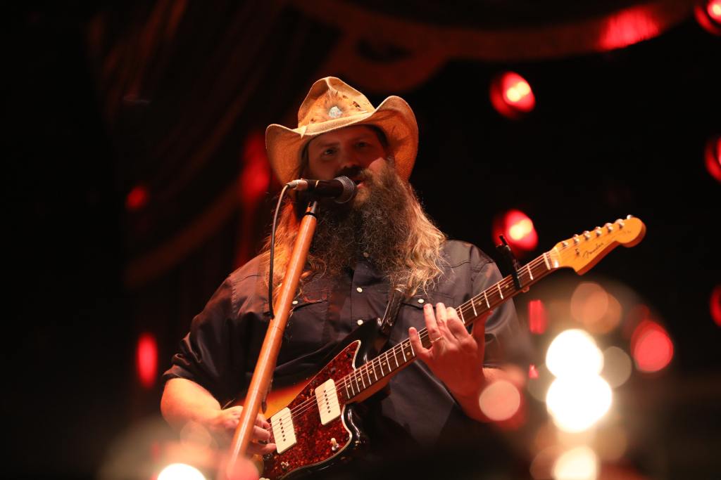 Chris Stapleton performing on stage with an electric guitar.