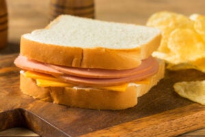 A Packed Lunch of Bologna Sandwich With Potato Chips