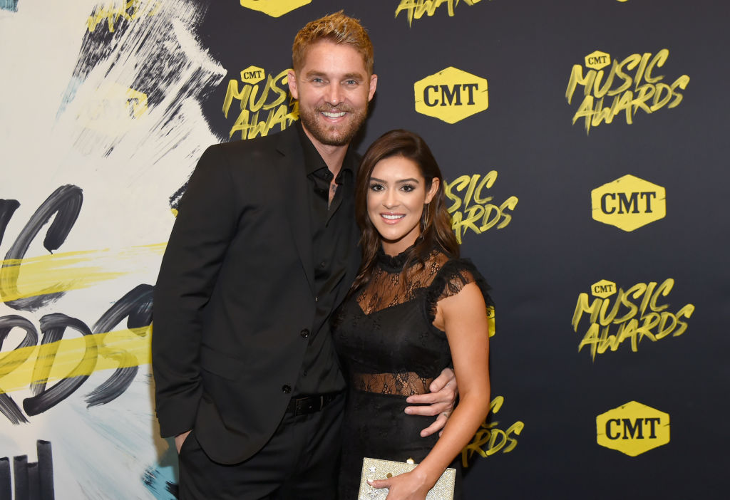 Brett young on red carpet holding his wife's hip