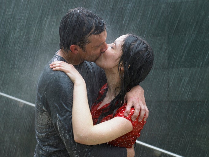 Couple kissing in rain, side view, close-up