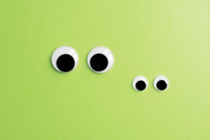 invisible frog googly eyes on green color background