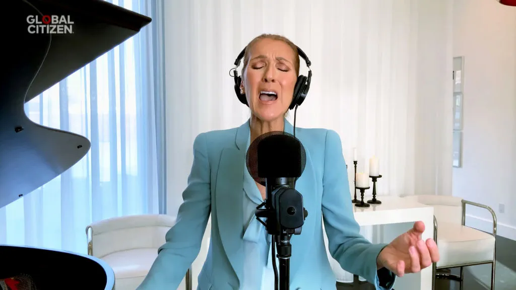 Celine Dion singing in a microphone from her home