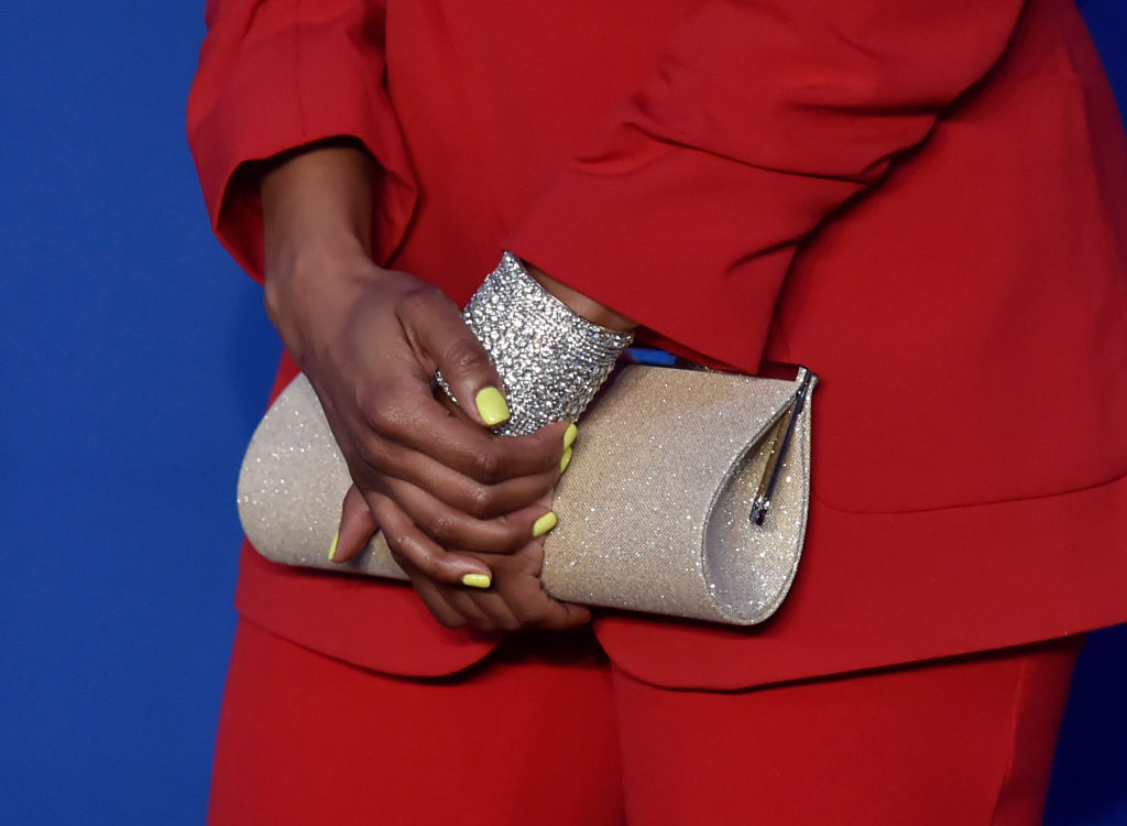 woman holding a purse with yellow nails