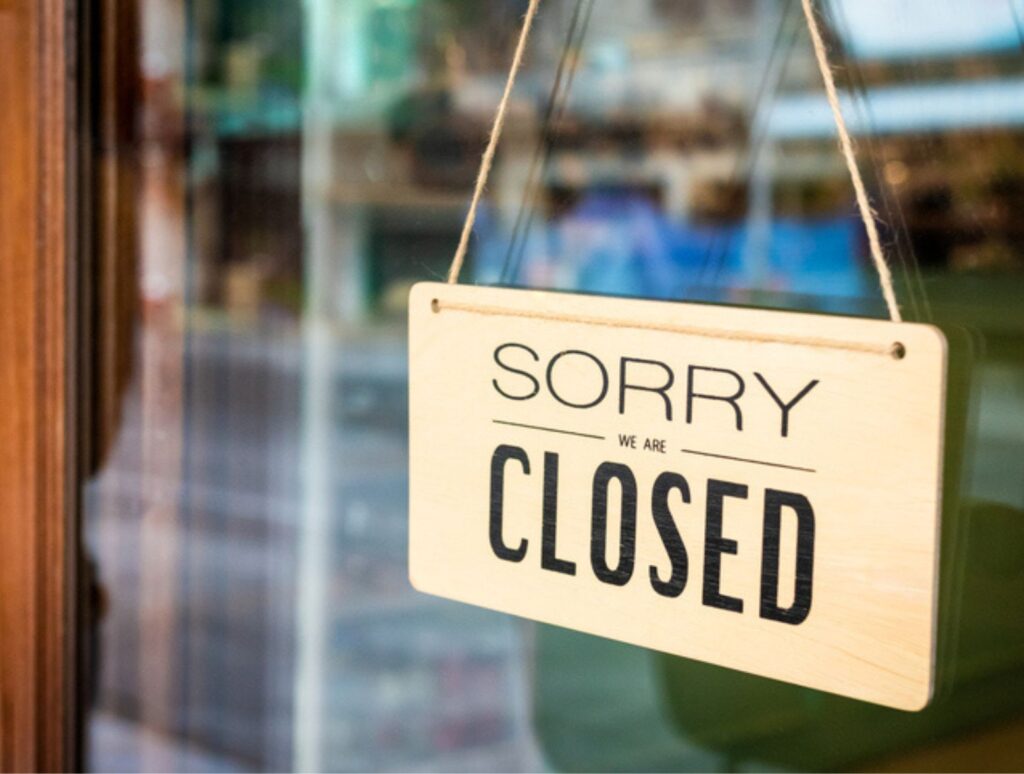 Sorry we are closed sign board hanging on door , closed retailers concept.