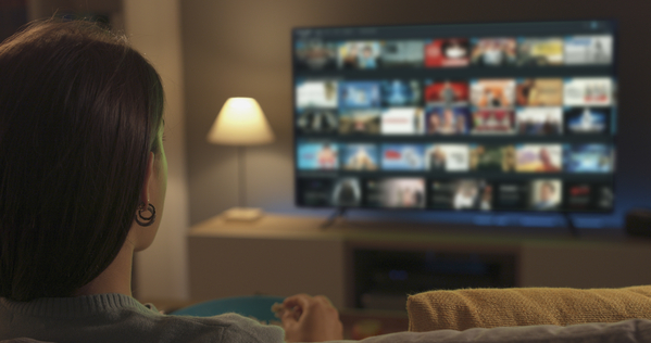 Young woman relaxing on the couch at home and watching tv