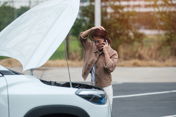 woman driver using mobile phone during problem car. Breakdown or broken car on road. Vehicle Insurance, maintenance and service concept