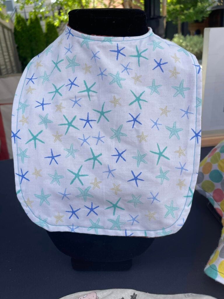 Ayla Brown bib with seashells on it