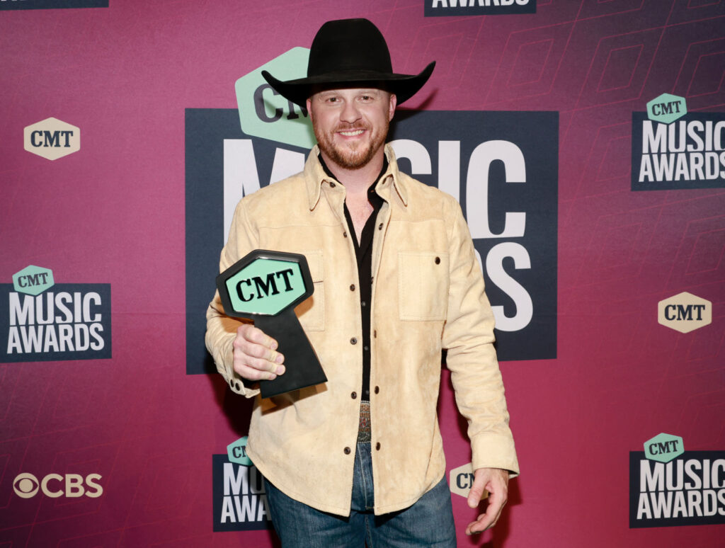Cody Johnson's 'The Painter' - Cody holding a CMT award in a tan shirt and black cowboy hat. 